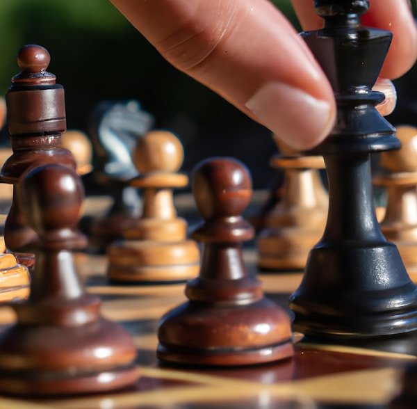 Person playing chess, hand moving a piece